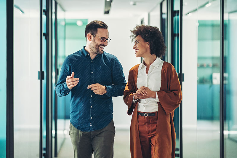 Colleagues walking and having friendly conversation about their next video project